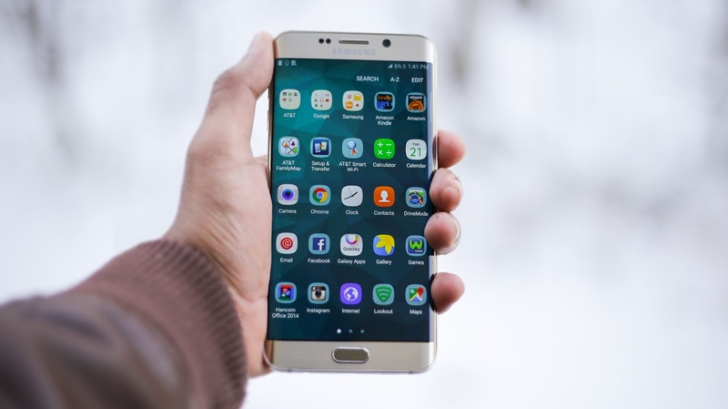Męska ręka trzymająca smartfon.
