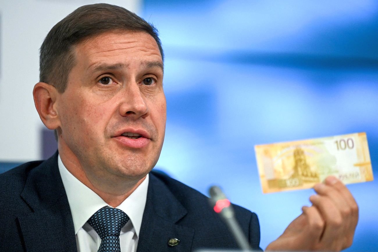Wiceprezes rosyjskiego banku centralnego Siergiej Biełow pokazuje nowy banknot 100-rublowy podczas oficjalnej prezentacji w Moskwie