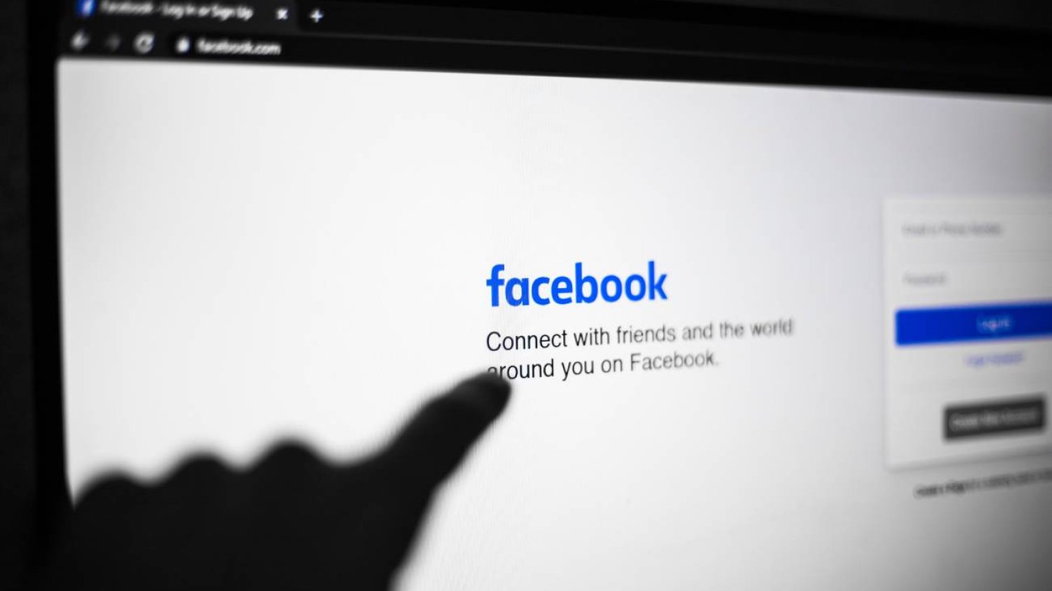 Ręka wskazująca na stronę facebook.com