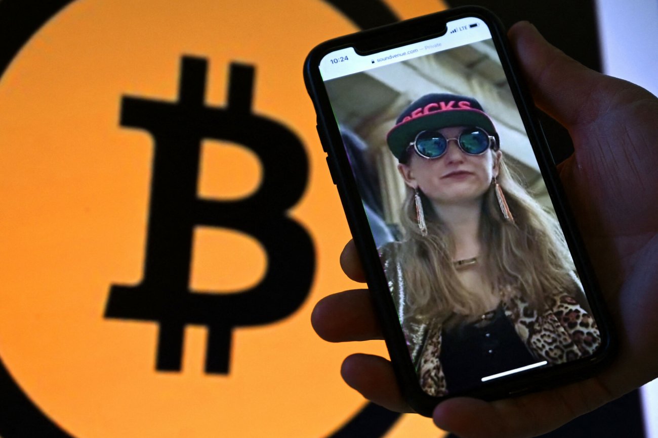 wyświetone na telefonie zdjęcie Heather Morgan, w tle logo Bitcoin