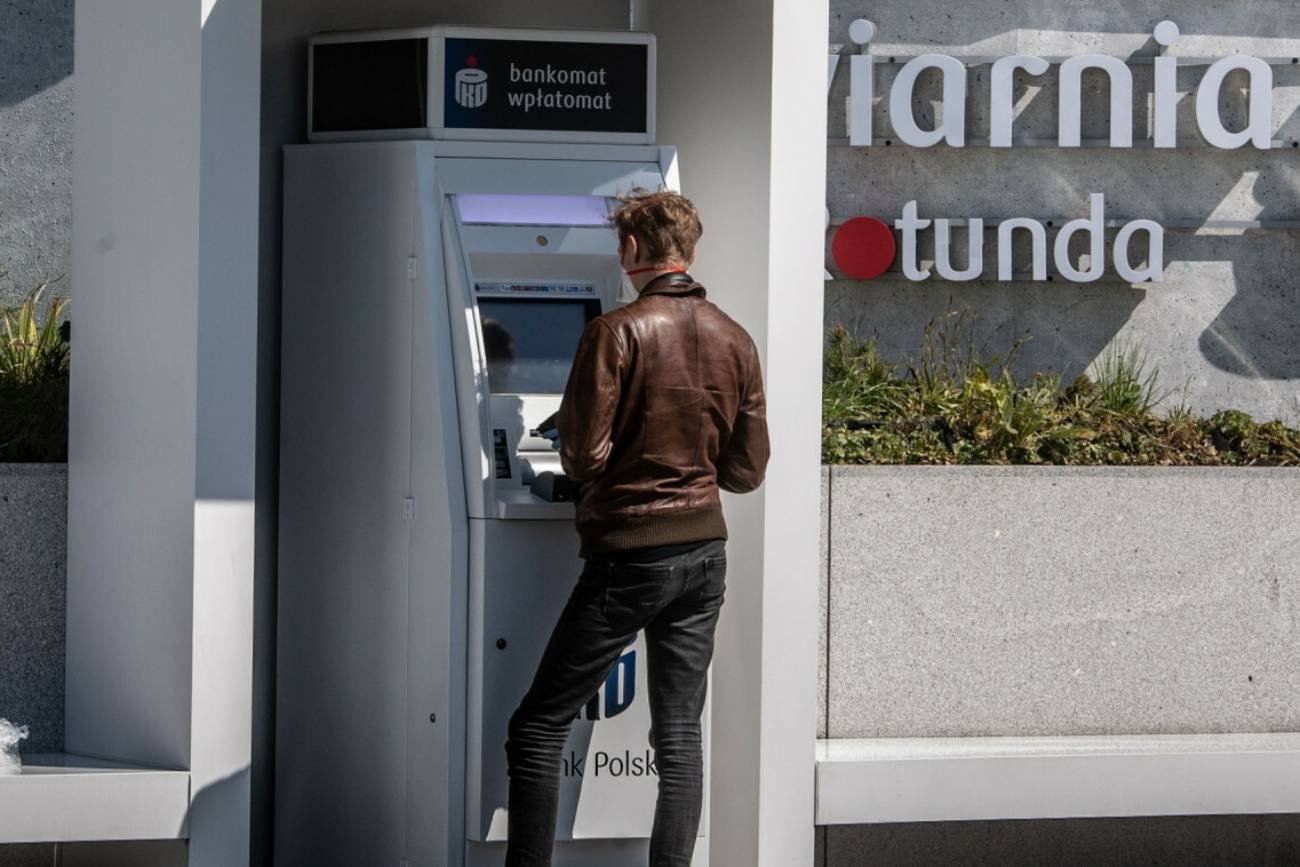 Mężczyzna przy bankomacie PKO BP