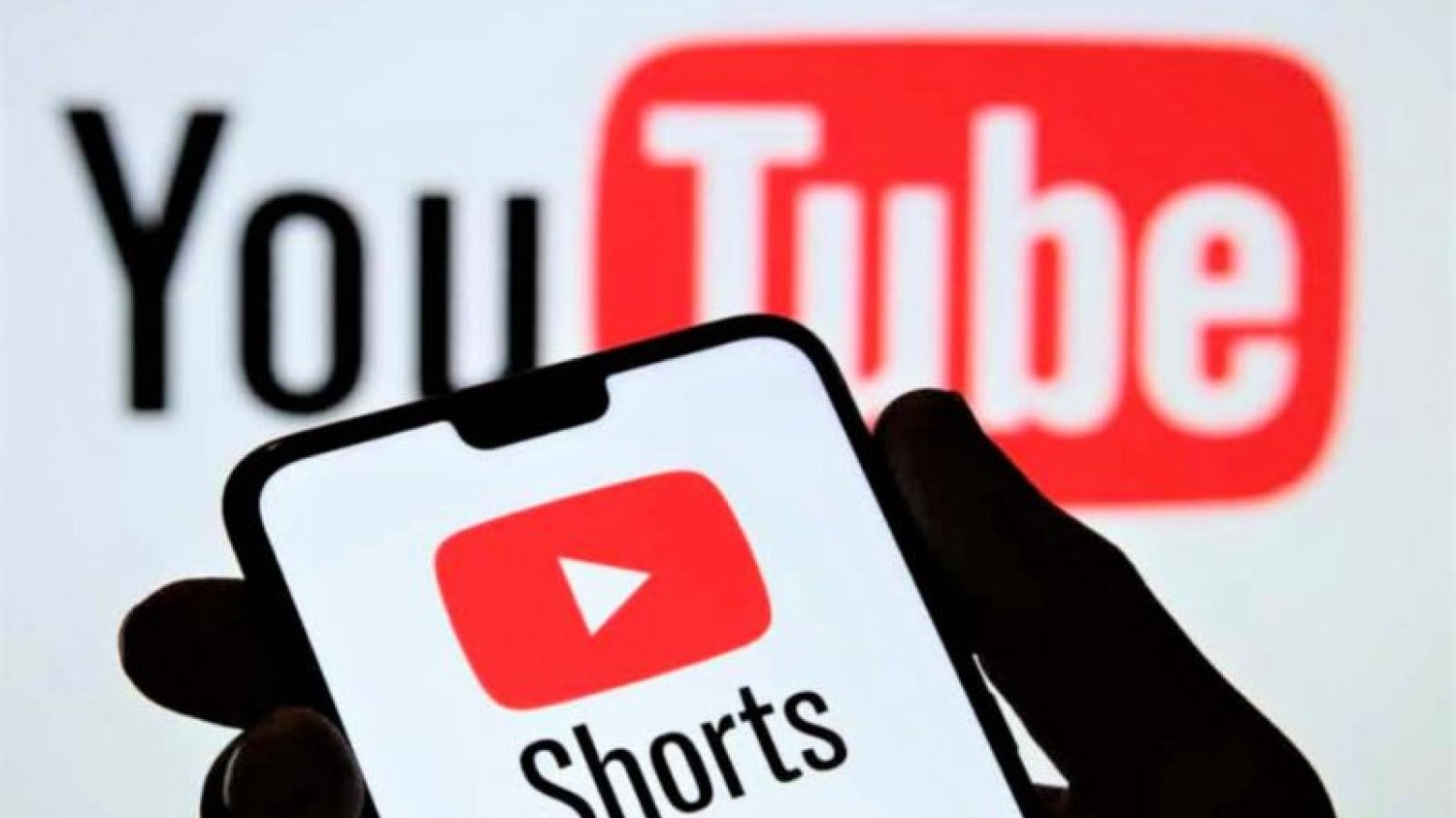 Ręka trzymająca smartfon z usługą youtube shorts.