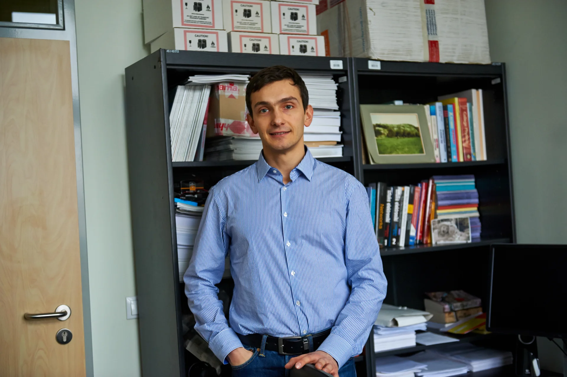 Dr Konrad Iwanicki w swoim pokoju na Uniwersytecie Warszawskim