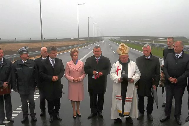 Minister Adamczyk (w środku) podczas otwarcia nowego odcinka drogi