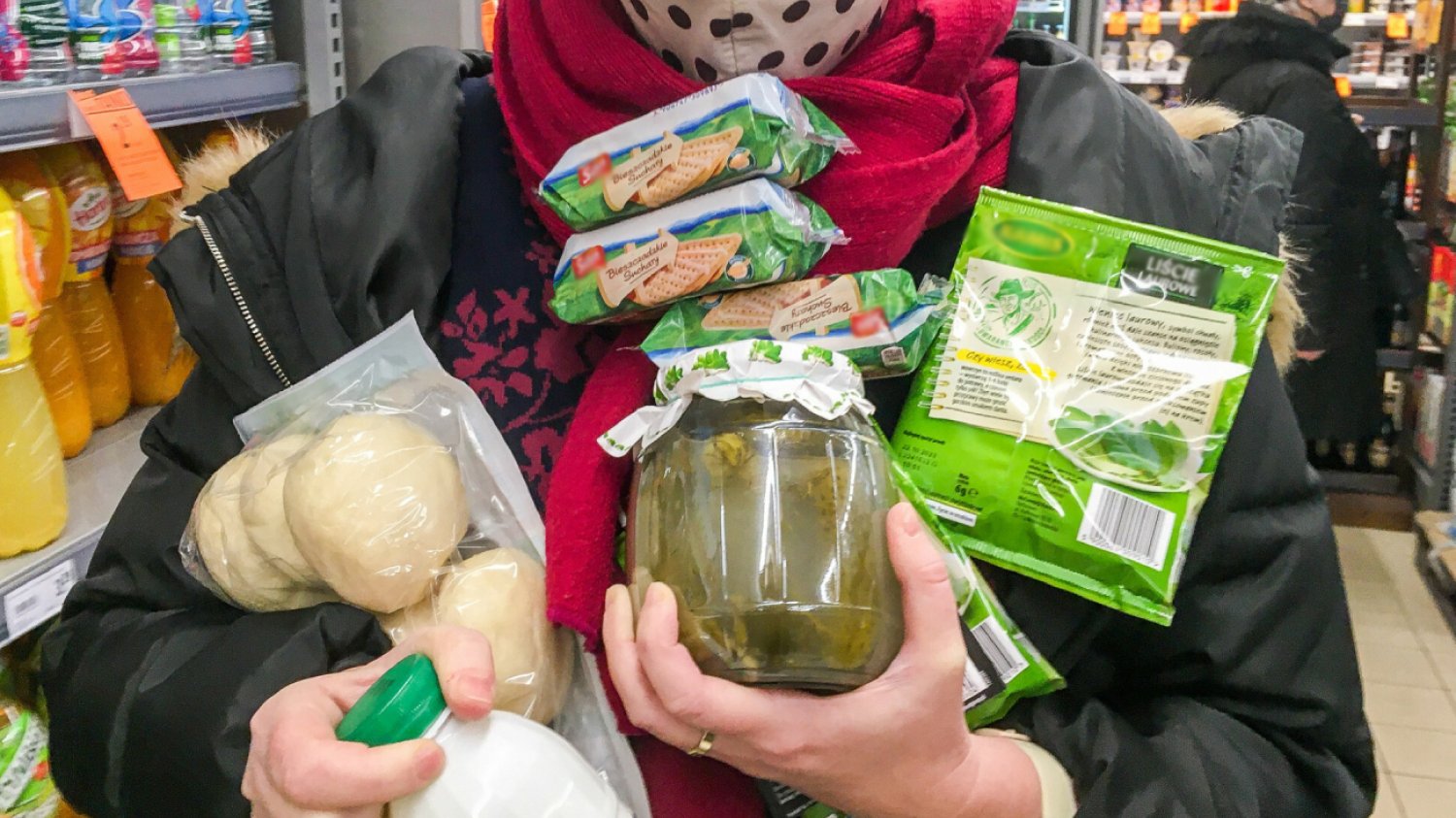 kobieta w maseczce na zakupach niesie na rękach różne produkty spożywcze potrzebne na śniadanie i obiad