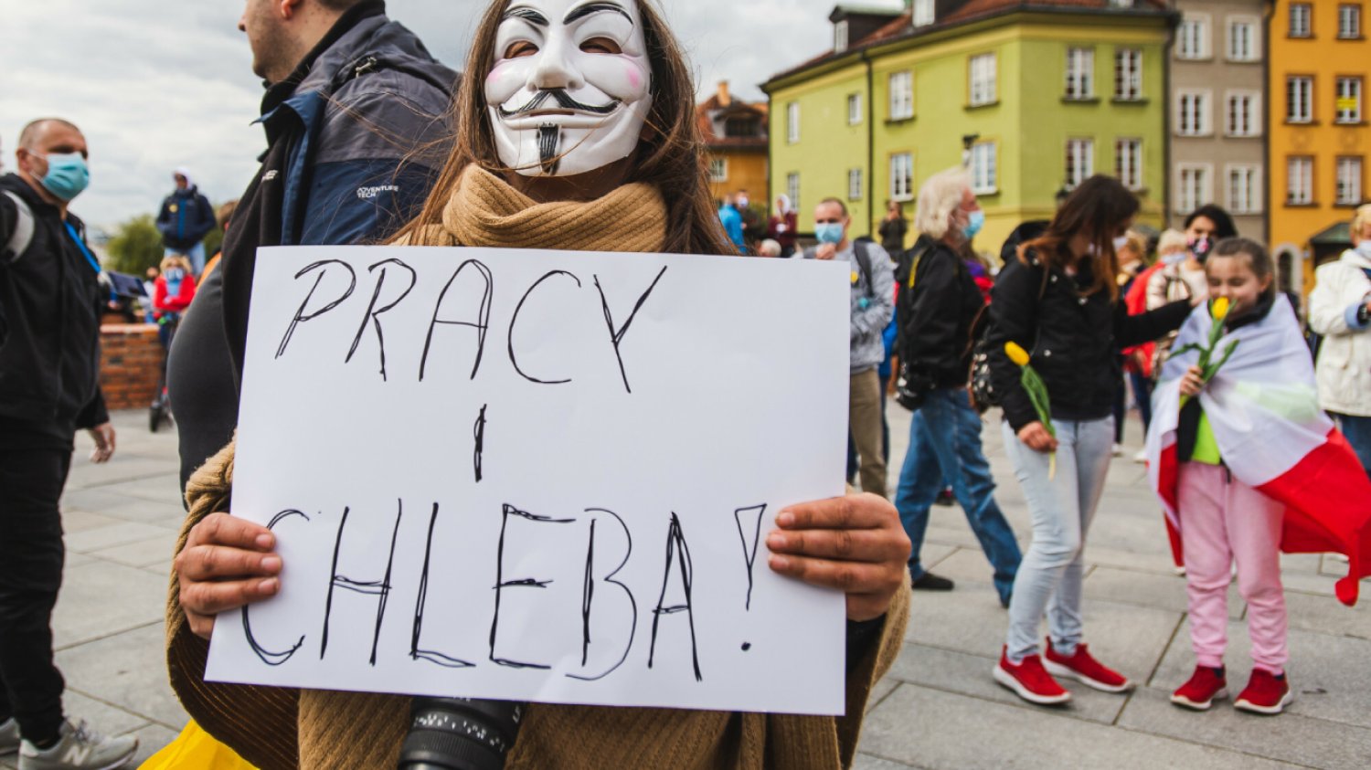 kobieta na strajku w Warszawie przy Kolumnie Zygmunta trzyma tabliczkę w napisem pracy i chleba