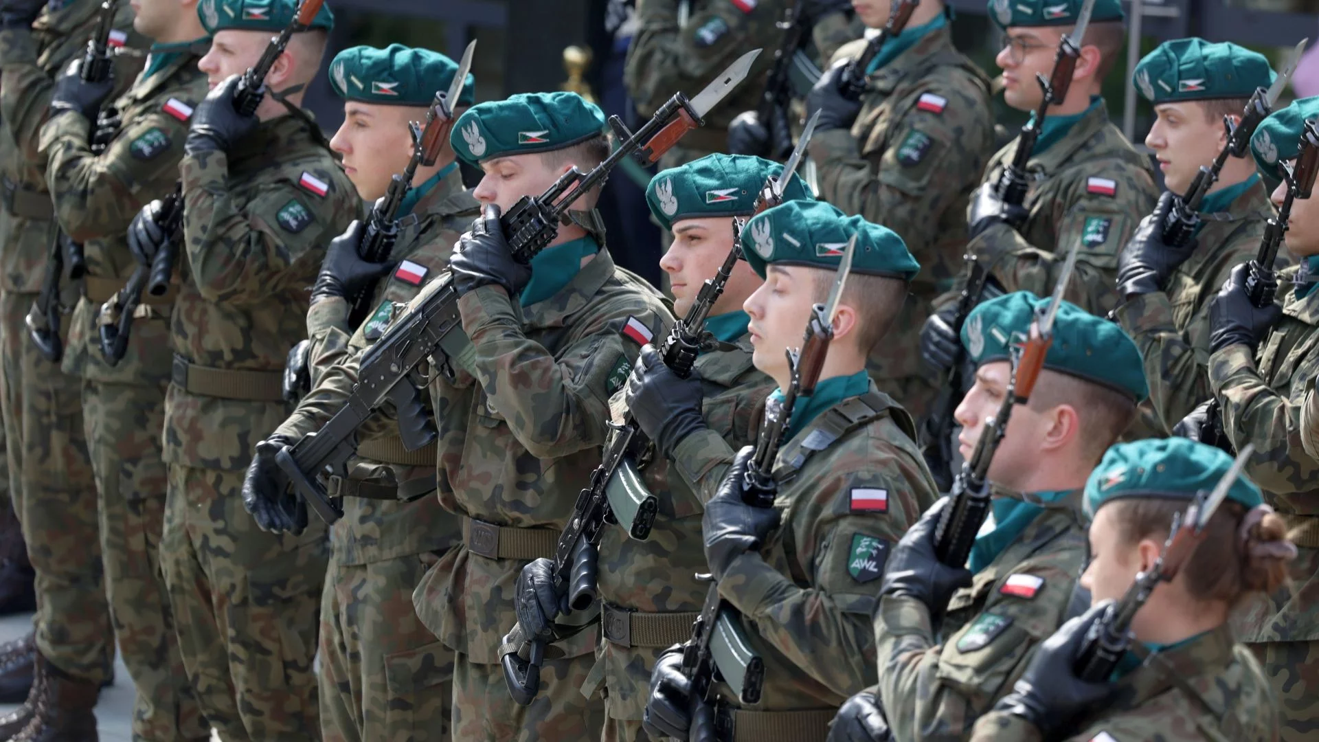 Nowy podatek na wojsko. Brauniści nie rzucą groszem w obliczu zagrożenia z Rosji. Polscy żołnierze i żołnierki z bronią w ręku stojący w szeregu. Nowy podatek na wojsko nie do zaakceptowania przez zwolenników Grzegorza Brauna.