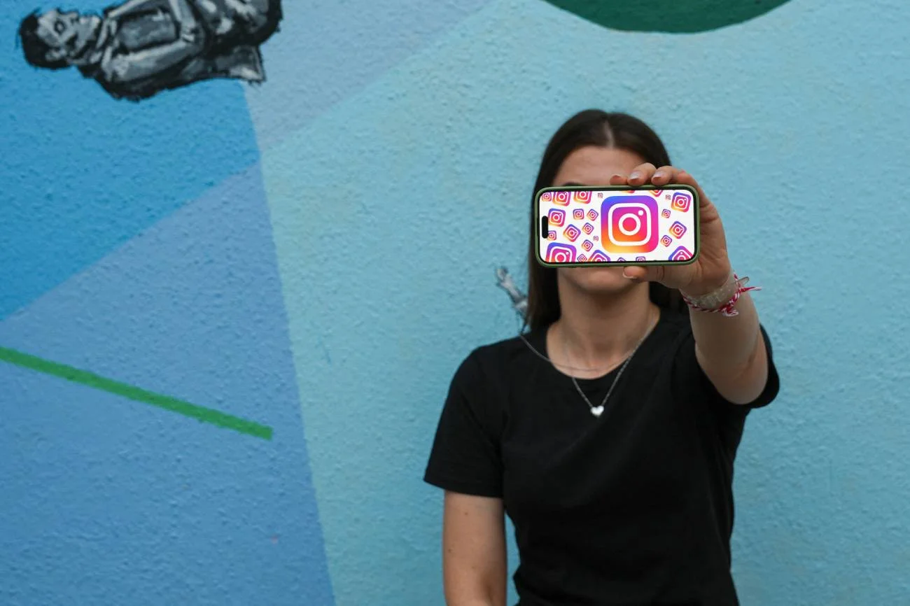 Kobieta trzymająca smartfon z logo Instagrama.