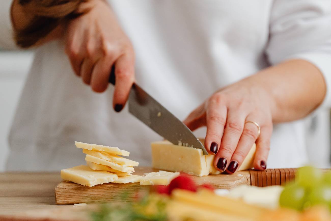 kucharka kroi ser stalowym nożem