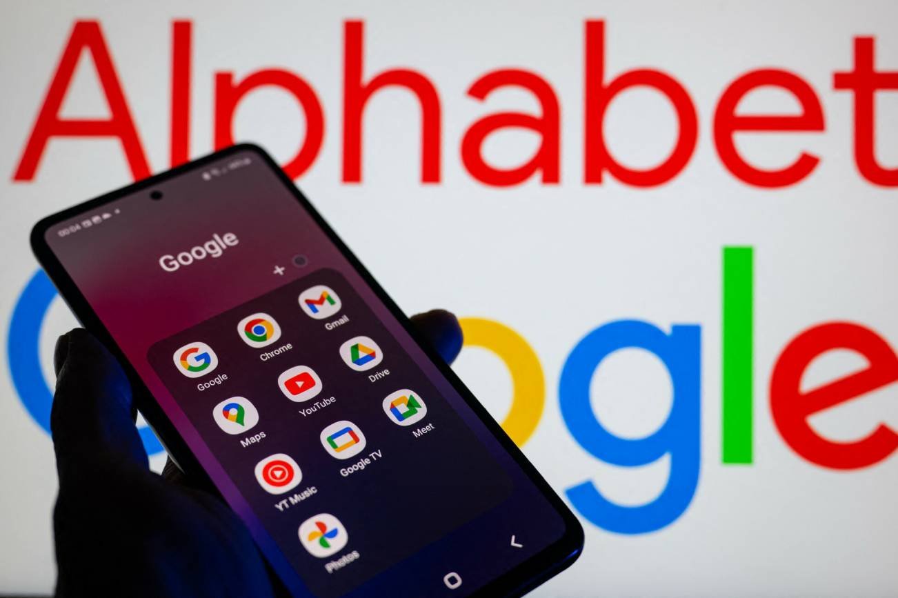 Dłoń trzymająca smartfon z apkami Google.