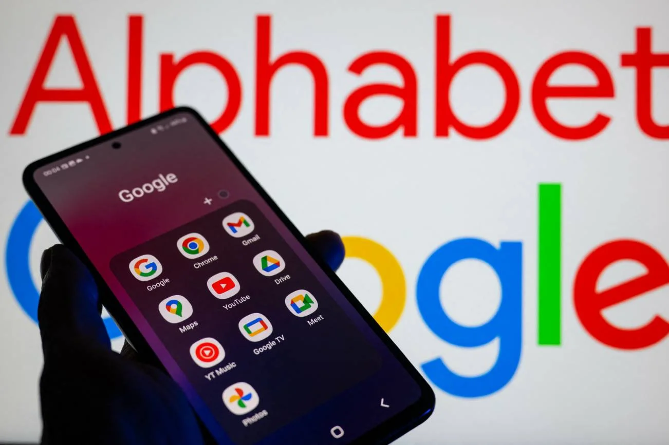 Dłoń trzymająca smartfon z apkami Google.