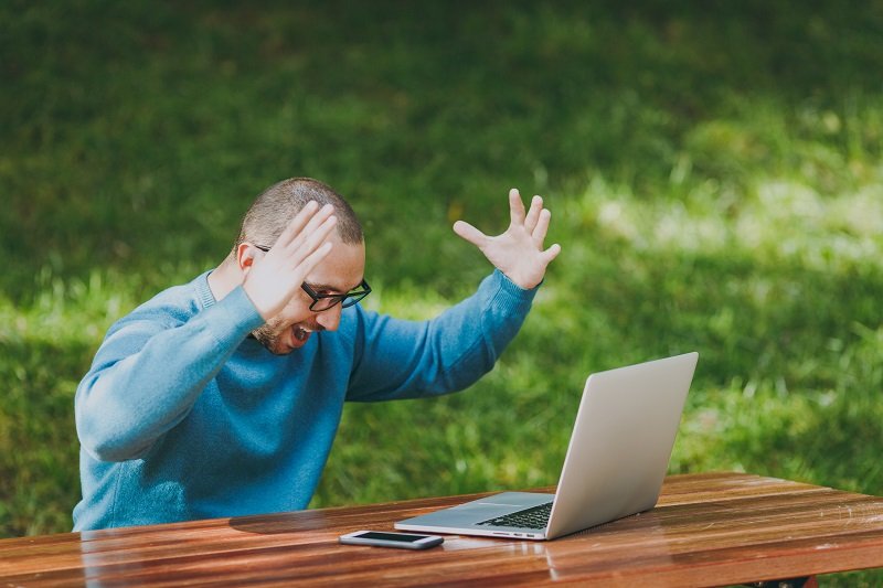 Zdenerwowany człowiek przed komputerem.