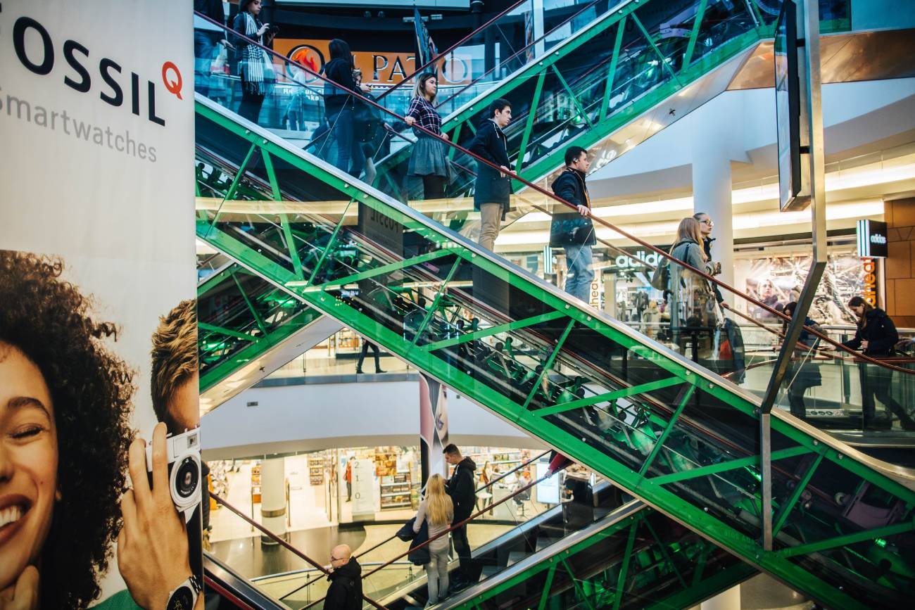 ludzie na ruchomych schodach w galeriach handlowych