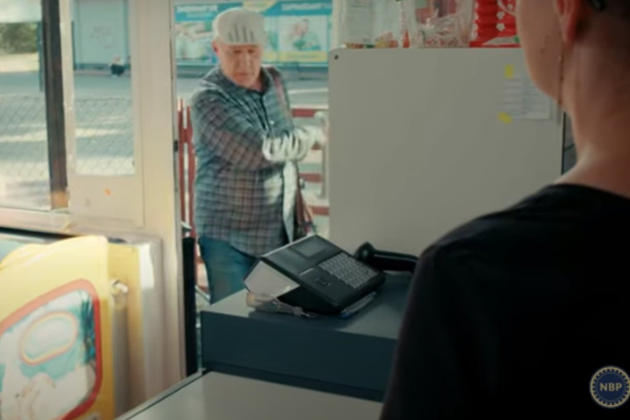 Mężczyzna i kasjerka w nowym spocie NBP.