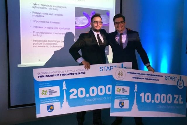 Mirosław Kaźmierczak z czekiem na 20 000 zł na scenie jednego z konkursów dla start-upów