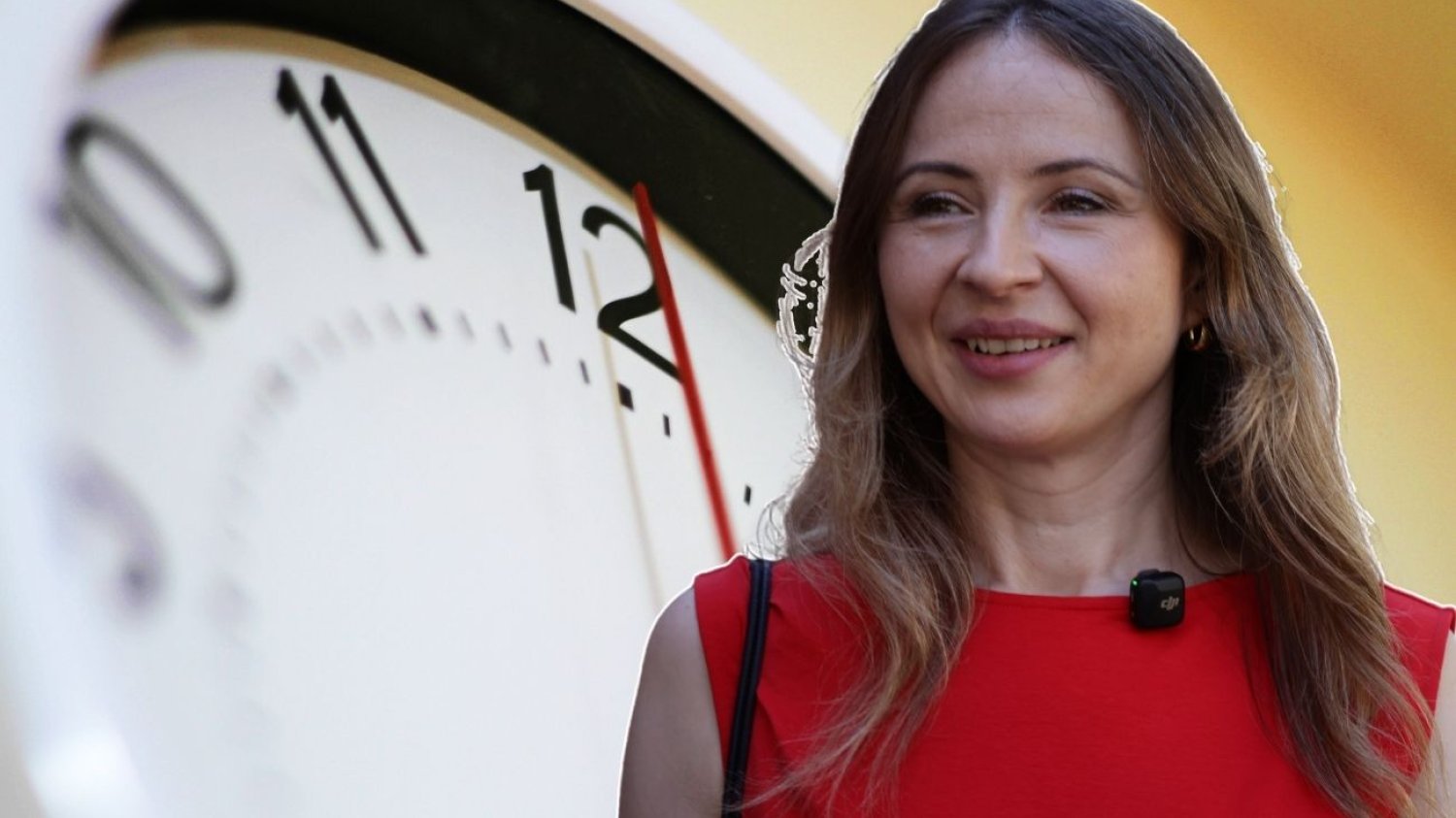Ministra Agnieszka Dziemianowicz-Bąk na tle tarczy zegara.