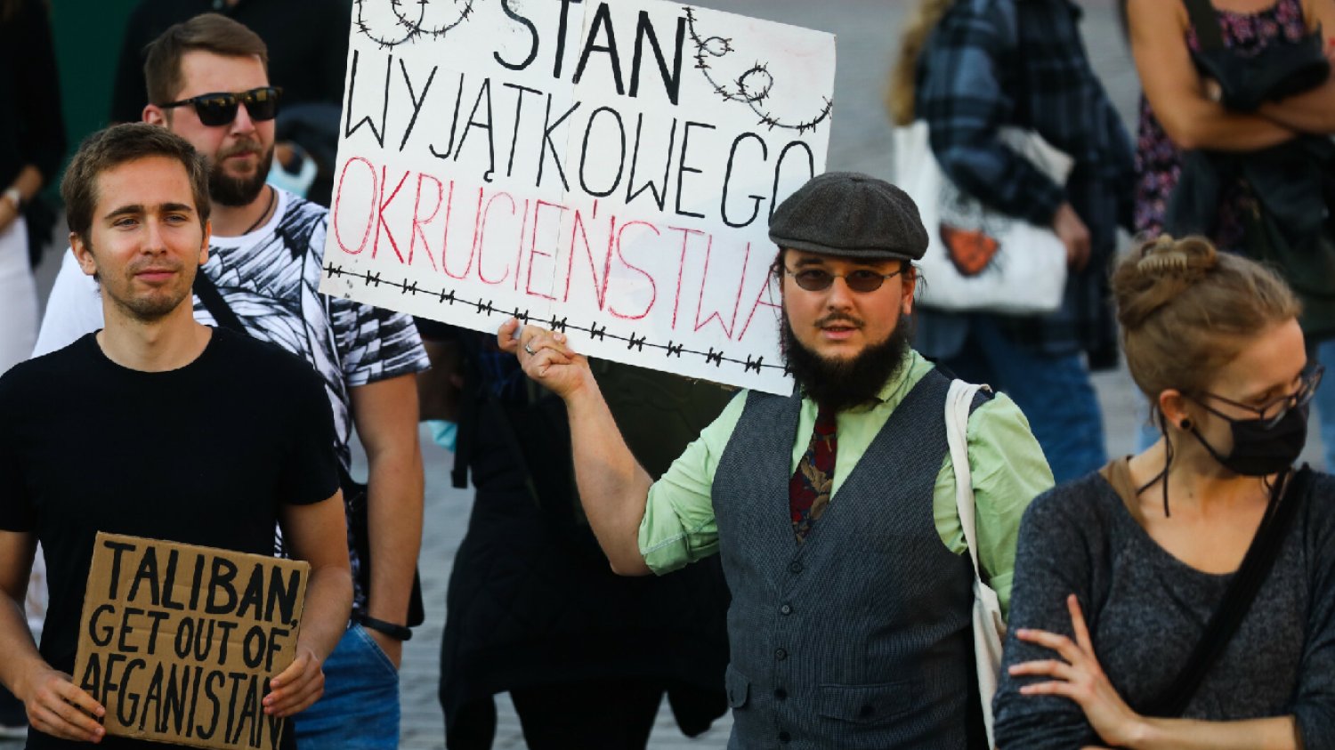 protest na granicy z Białorusią, ludzie trzymają transparenty z napisami na proteście