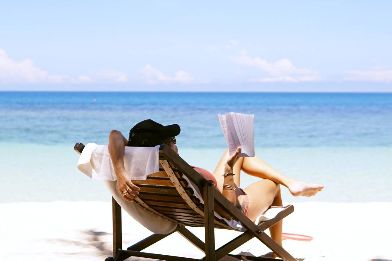 kobieta z książką na plaży