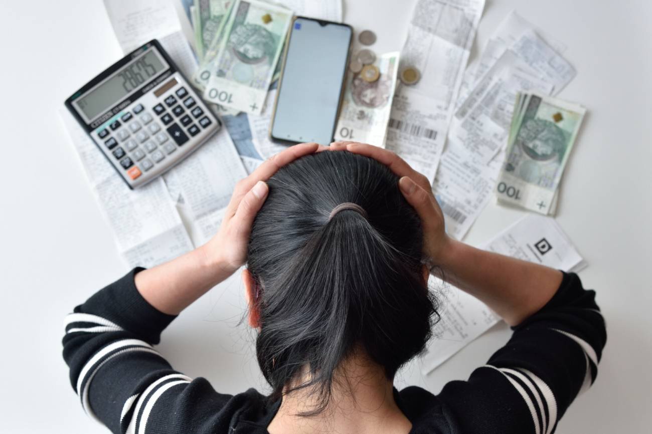 Kobieta licząca ratę kredytu z kalkulatorem