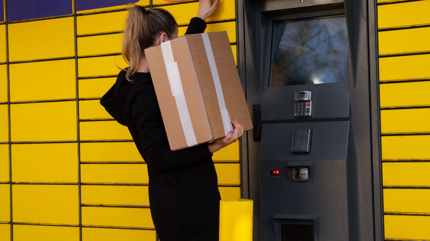 Zmiany w InPost od marca: Jedni zapłacą mniej, inni zapłaczą. Kobieta odbiera paczkę w paczkomacie InPost.