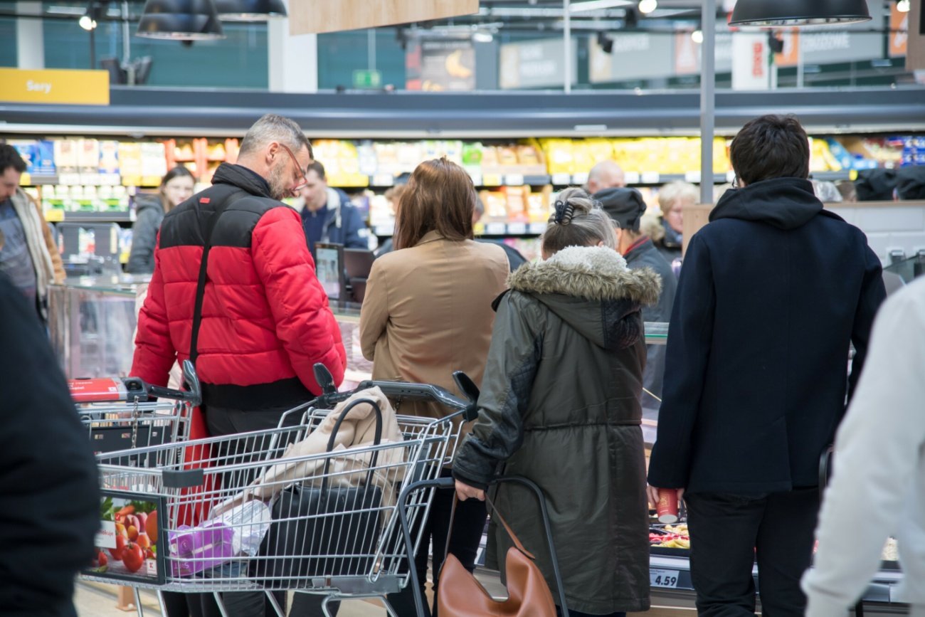 Klienci w supermarkecie, wózek z zakupami.