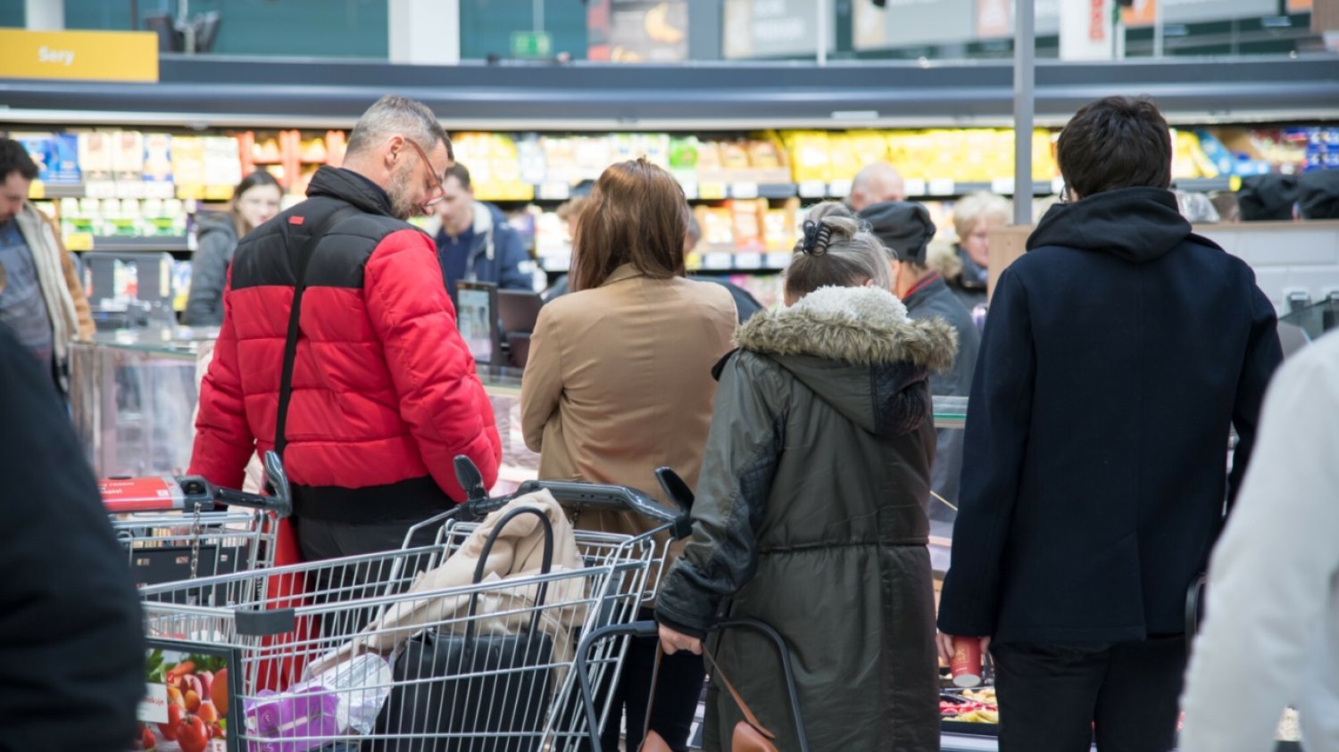 Klienci w supermarkecie, wózek z zakupami.
