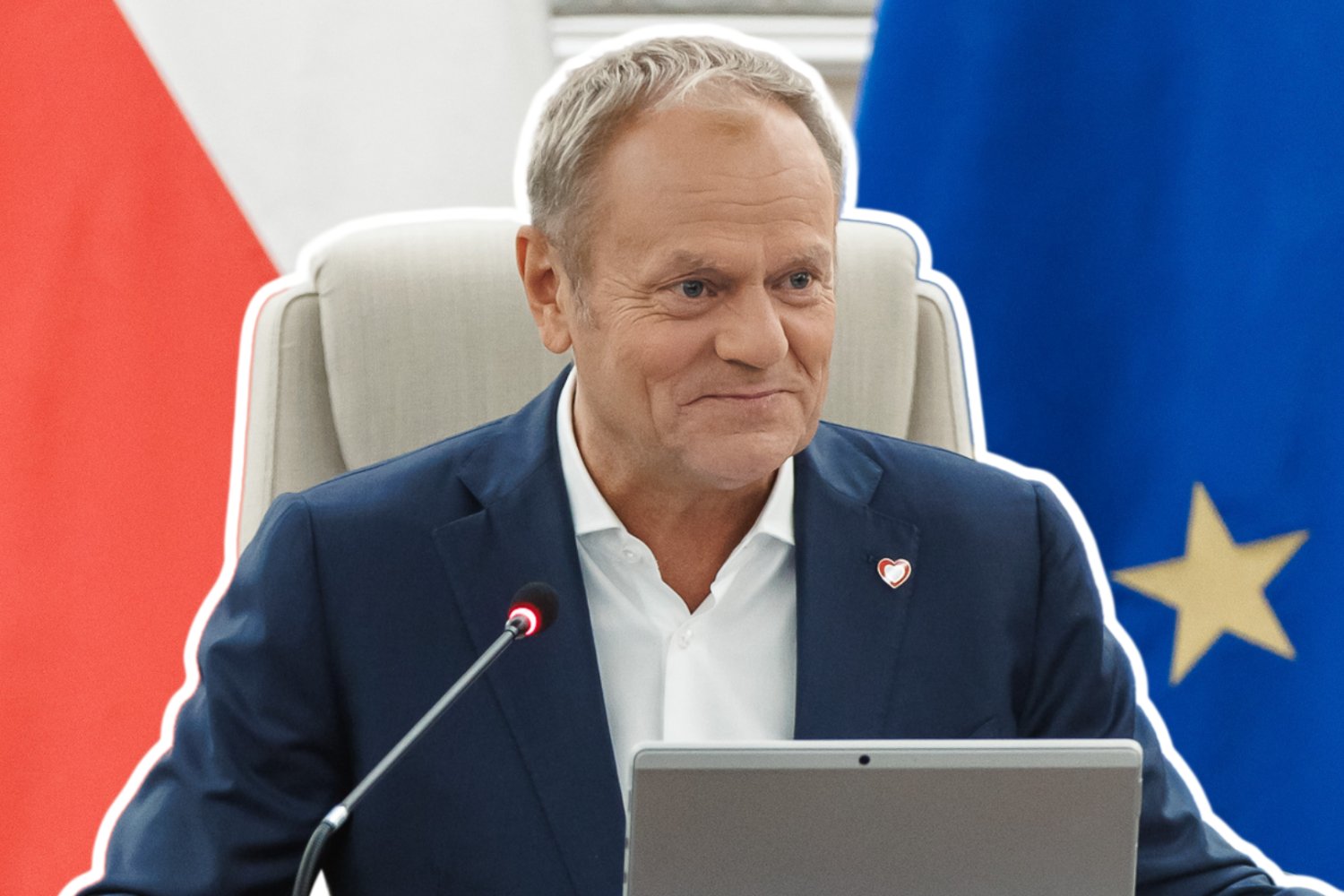Donald Tusk na fotelu. W tle flaga Unii Europejskiej i Polski