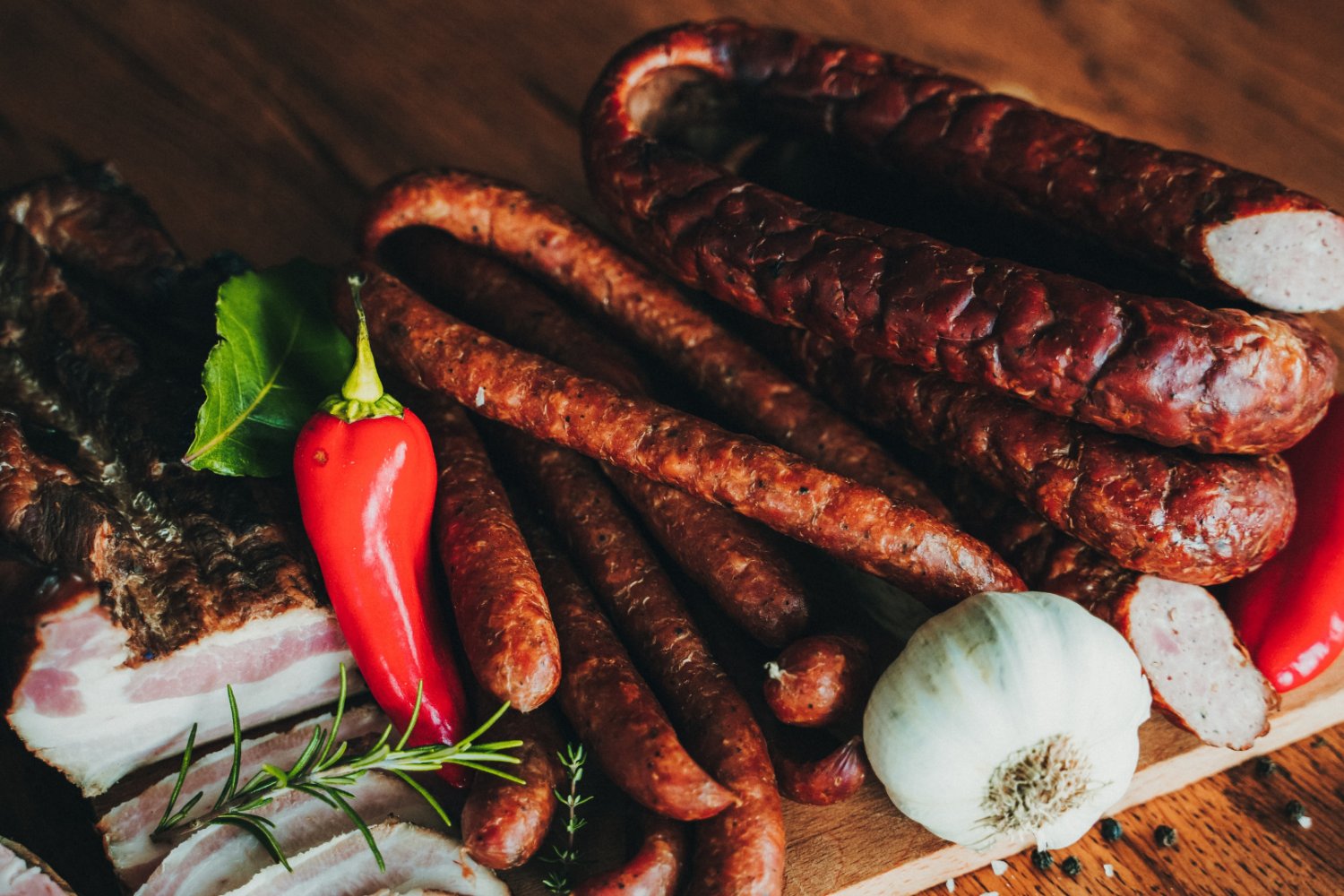 Produkty mięsne na drewnianej desce. Kiełbasa, szynka.