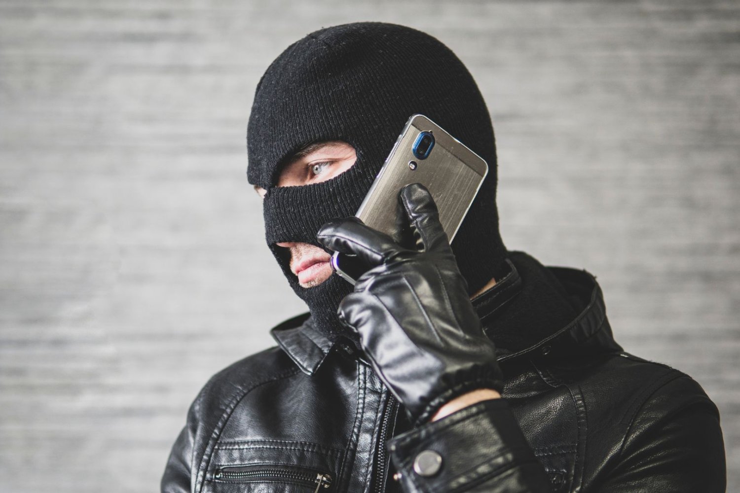 Fałszywe wezwania z ZUS-u zalewają Polaków. Co trzeci Polak dostał taki telefon lub SMS Człowiek w kominiarce używa telefony. Co trzeci Polak dostał taki telefon. Oszuści podszywają się pod urzędy i policje