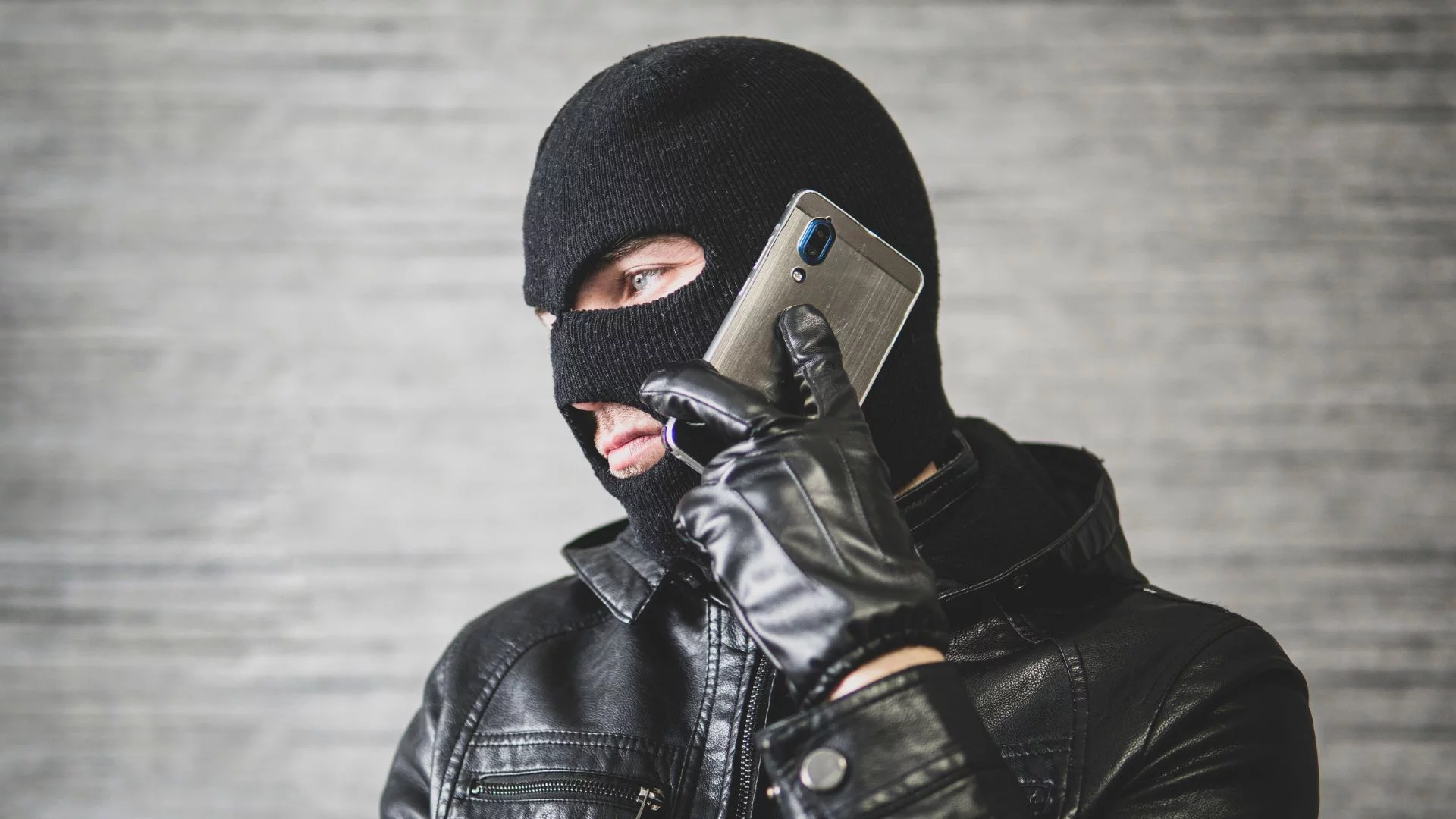 Fałszywe wezwania z ZUS-u zalewają Polaków. Co trzeci Polak dostał taki telefon lub SMS Człowiek w kominiarce używa telefony. Co trzeci Polak dostał taki telefon. Oszuści podszywają się pod urzędy i policje