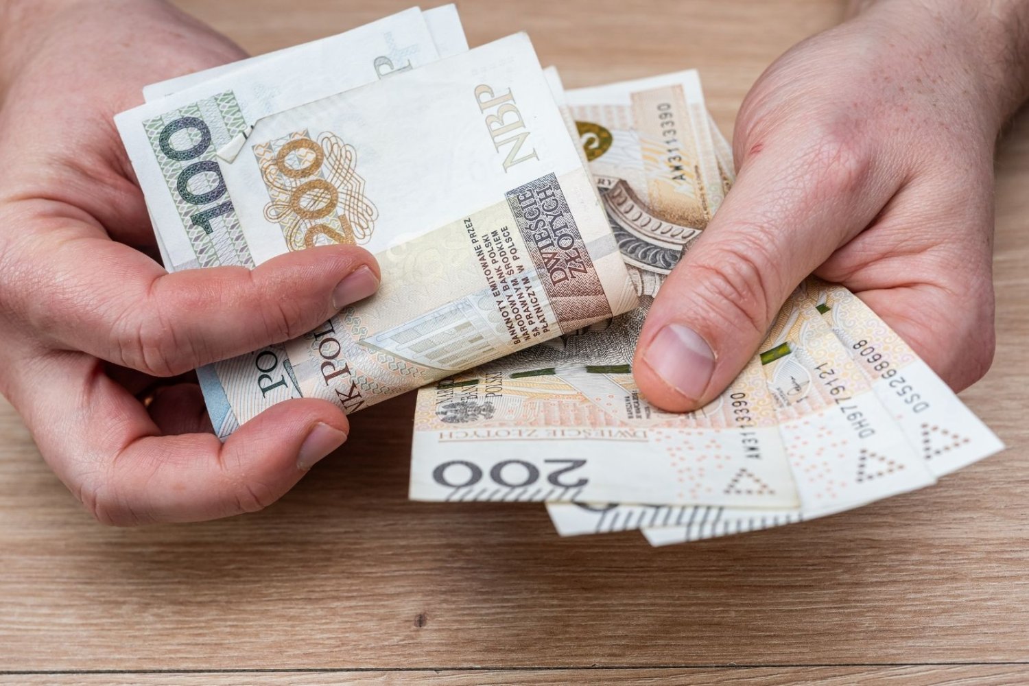 człowiek z pieniędzmi w dłoniach.
