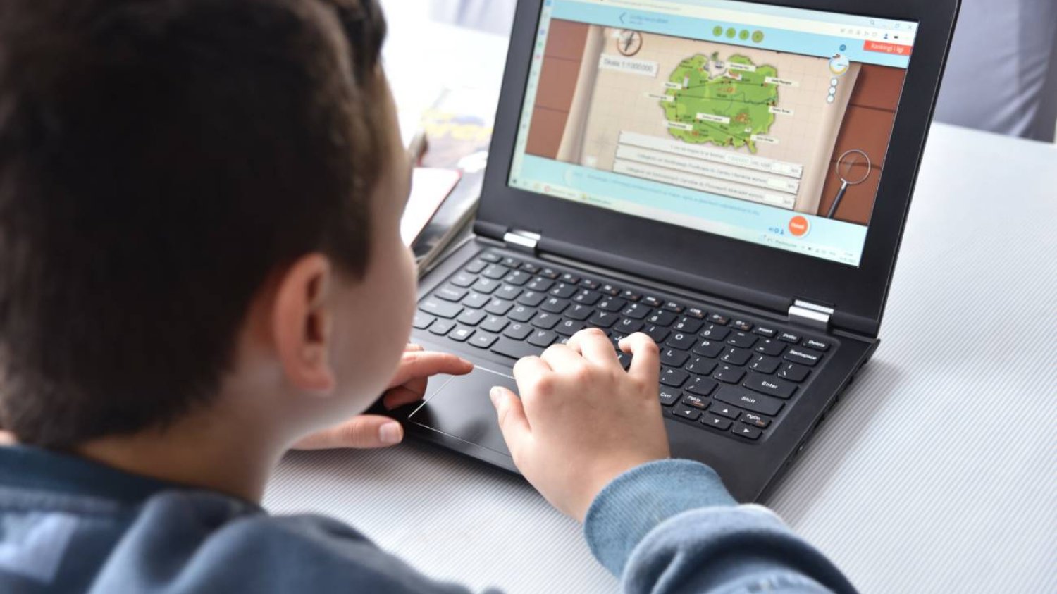 Uczeń przed laptoptem.