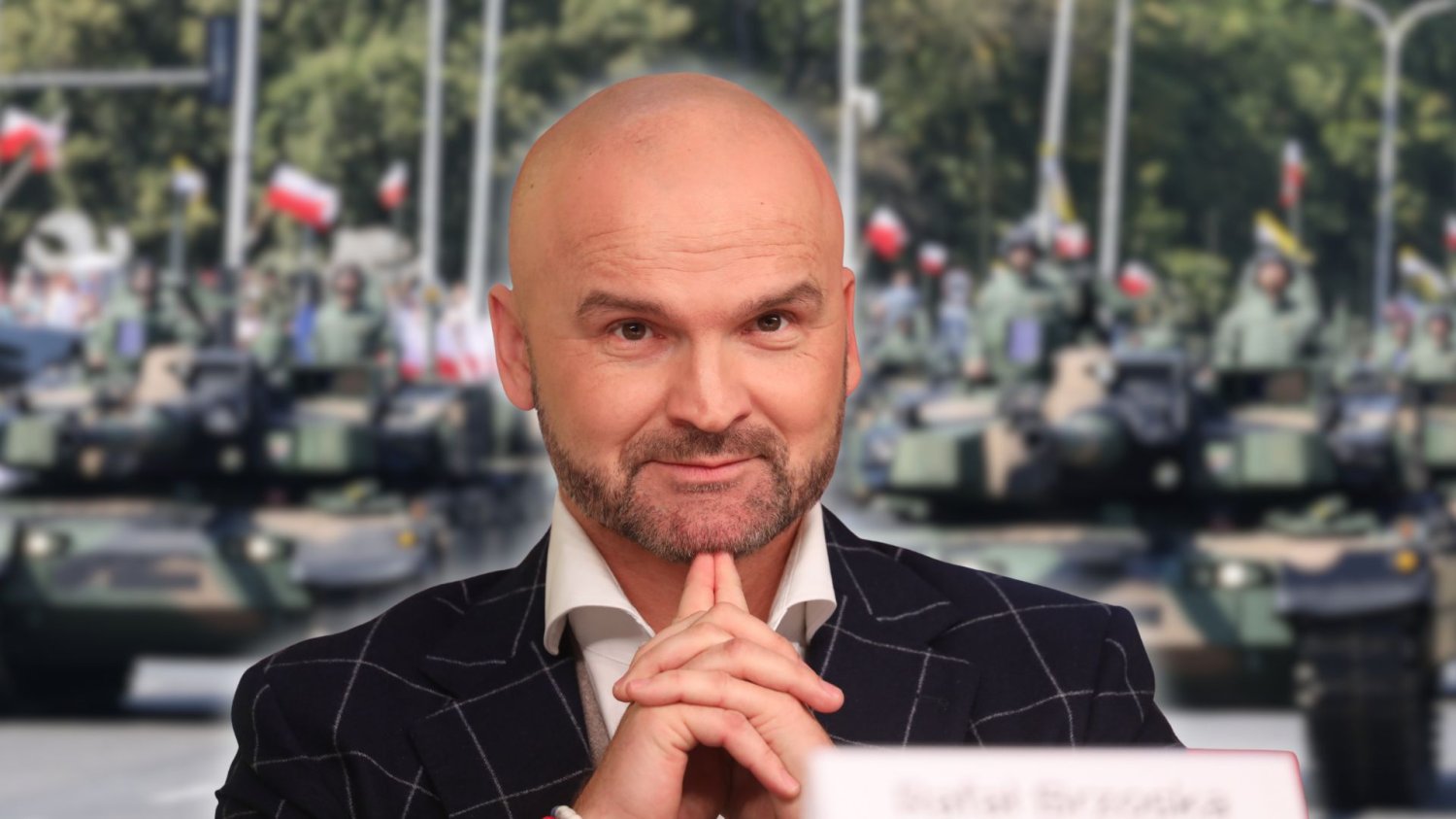 Rafał Brzoska na tle defilady Wojska Polskiego. Przedsiębiorca jest współautorem raportu o zaangażowaniu sektora biznesu do celów bezpieczeństwa narodowego.