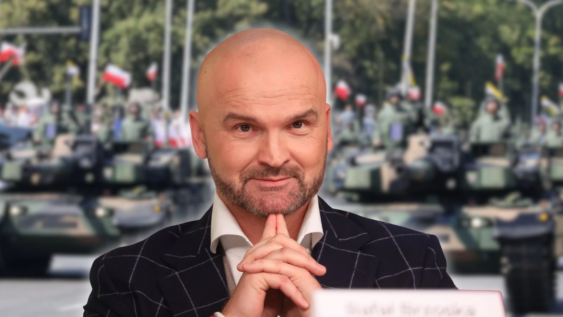 Rafał Brzoska na tle defilady Wojska Polskiego. Przedsiębiorca jest współautorem raportu o zaangażowaniu sektora biznesu do celów bezpieczeństwa narodowego.