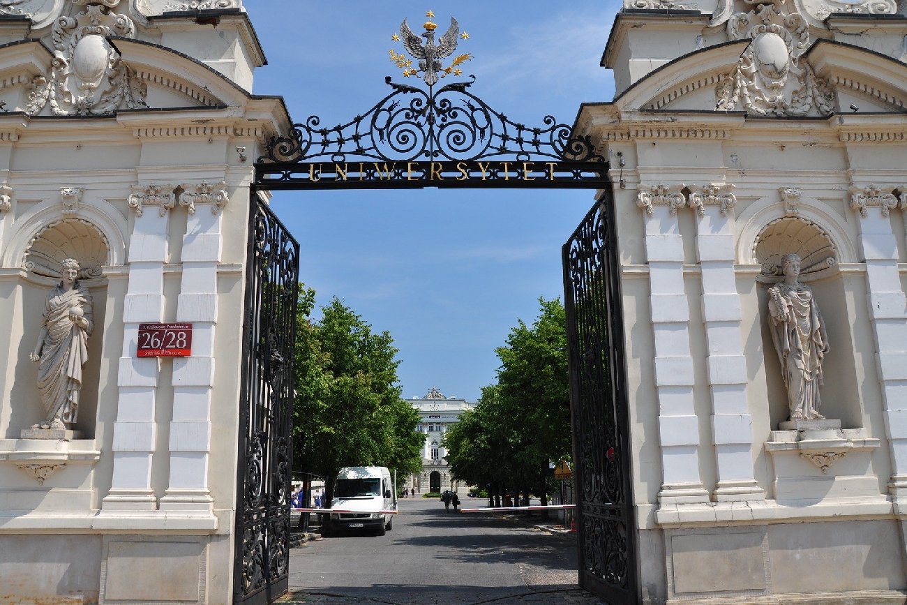 brama główna Uniwersytetu Warszawskiego w letni dzień na tle niebieskiego nieba bez chmur