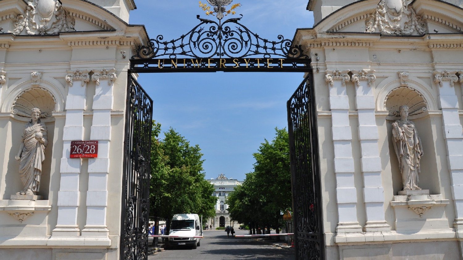 brama główna Uniwersytetu Warszawskiego w letni dzień na tle niebieskiego nieba bez chmur