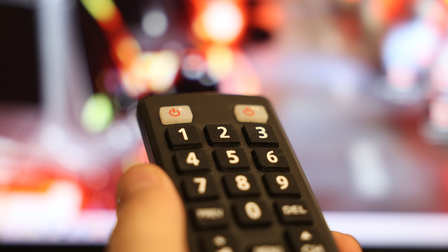 Polacy rekordowo oglądają streamingi, a Netflix nie jest królem. Pogoda przymroziła nas do ekranów Ręka z pilotem od telewizora. W styczniu siedzieliśmy ponad 4 godziny dziennie przed ekranem.