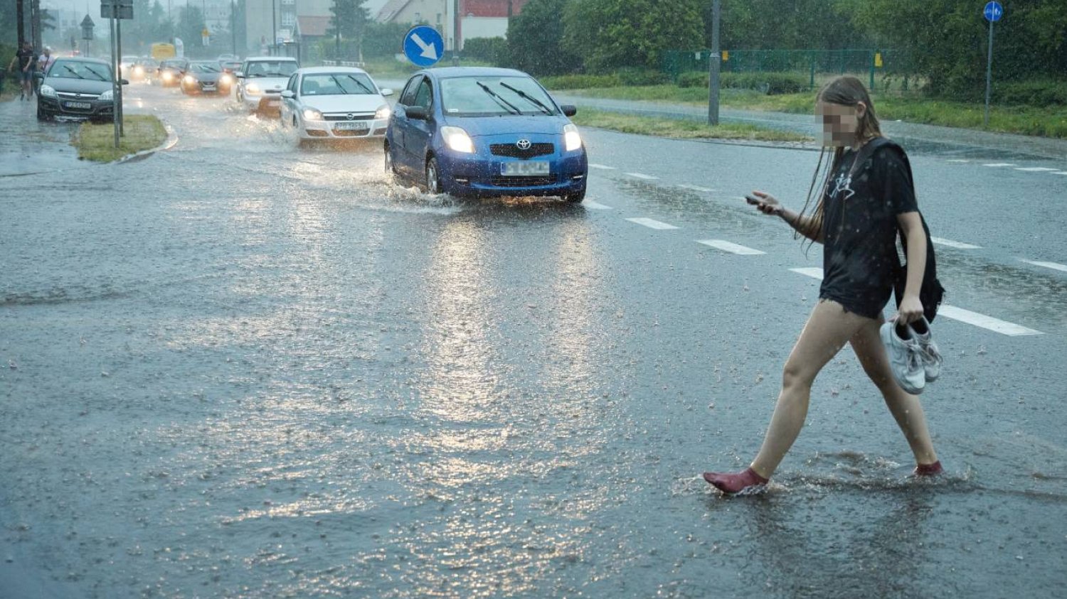 Dziewczyna przechodząca przez zalaną ulicę