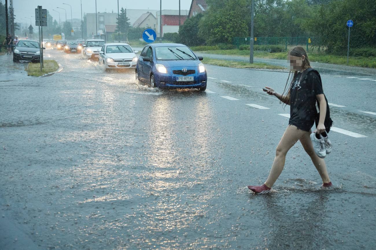 Dziewczyna przechodząca przez zalaną ulicę