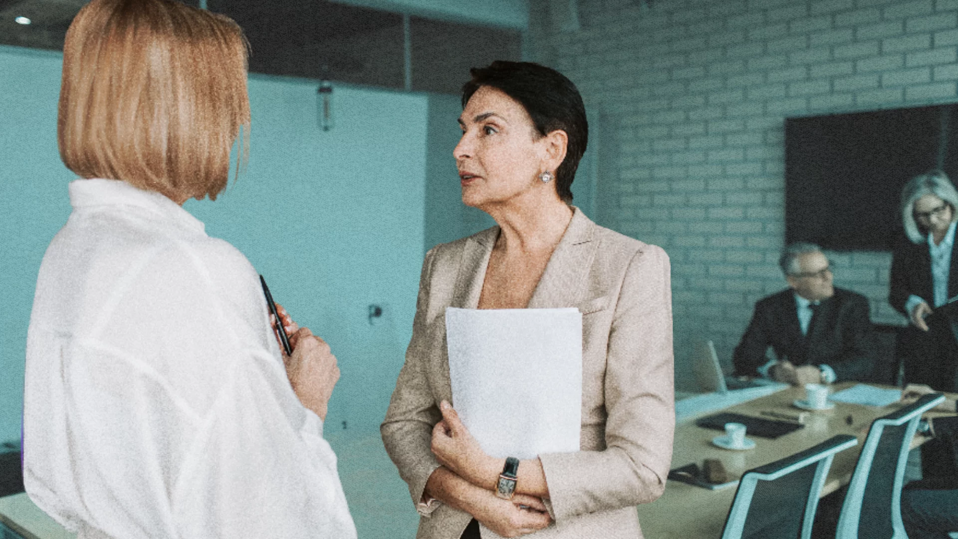 Dwie kobiety rozmawiają w pracy. Jak skutecznie prosić o podwyżkę?