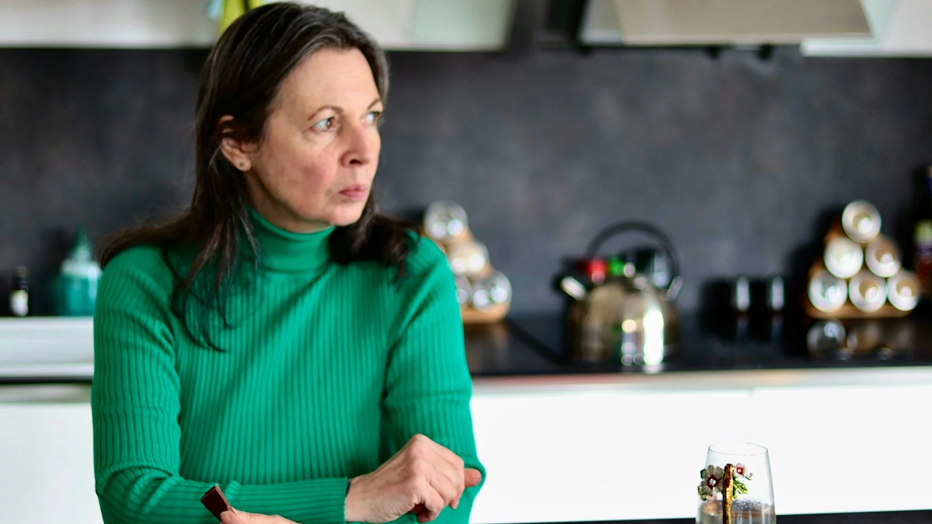 Niemieccy rodzice martwią się o swoje nastoletnie dzieci – chcą je ochronić przed poborem do wojska. Kobieta siedząca w kuchni przy stole patrząca z poważną miną w bok. Niemieccy rodzice chcą ochronić nastoletnie dzieci przed poborem do wojska.