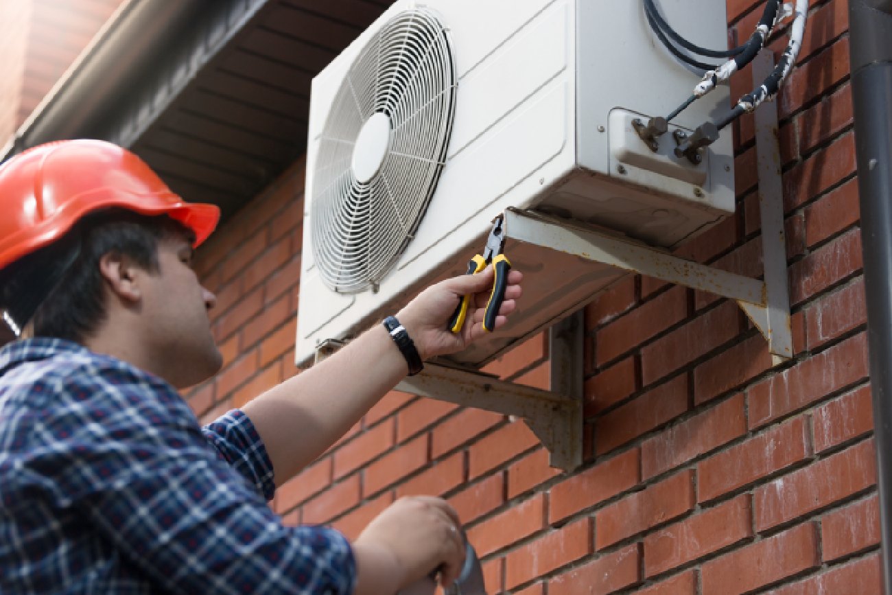 Monter klimatyzacji zakładający klimatyzator na domu jednorodzinnym