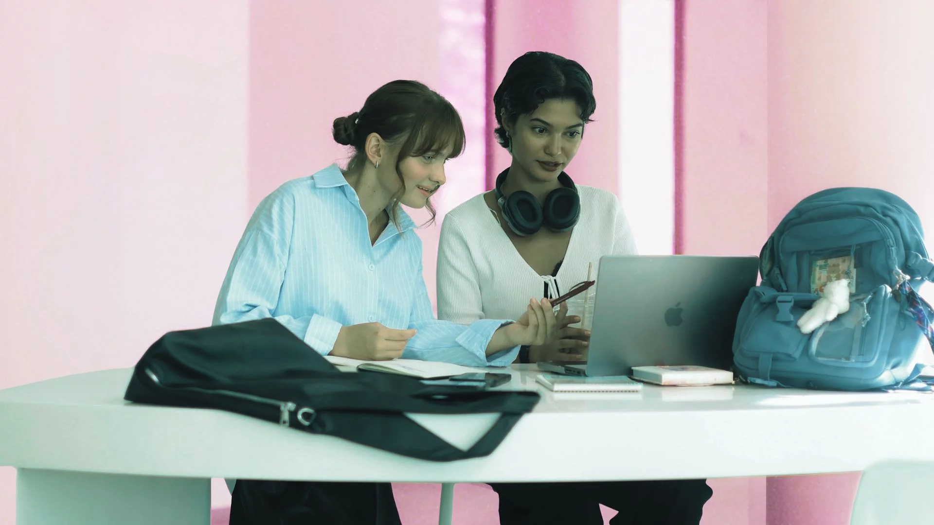 Dwie młode kobiety pracują przy jednym laptopie.