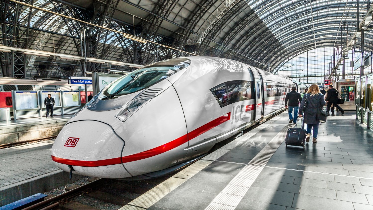 Niemiecki gigant szuka oszczędności. Deutsche Bahn zaczyna od własnego zarządu Pociąg Deutsche Bann stojący na peronie. Na peronie podróżujący ludzie.