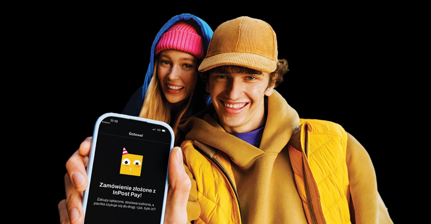 Jak budować przewagę e-sklepu dzięki nowoczesnemu checkoutowi. Dwie uśmiechnięte młode osoby, jedna z nich trzyma w ręku smartfon.