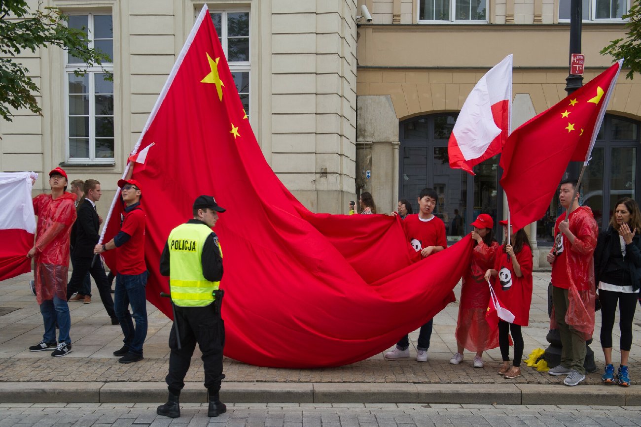 protest na ulicy, chińskie i polskie flagi w asyście policji