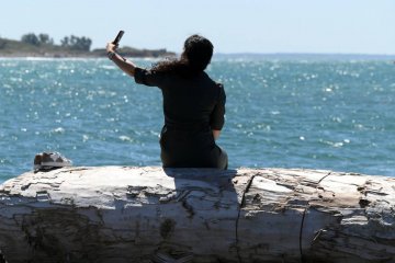 Influencer robiący selfie nad morzem.