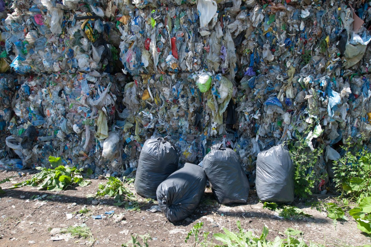 worki ze śmieciami na tle zgniecionych śmieci