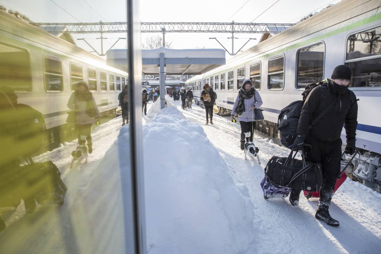 Pasażerowie na peronie zimą.