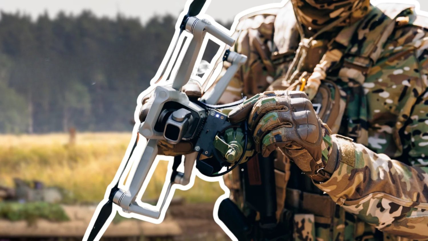 Zolnierz trzyma dron. Zolnierz doczepia bombę do drona.